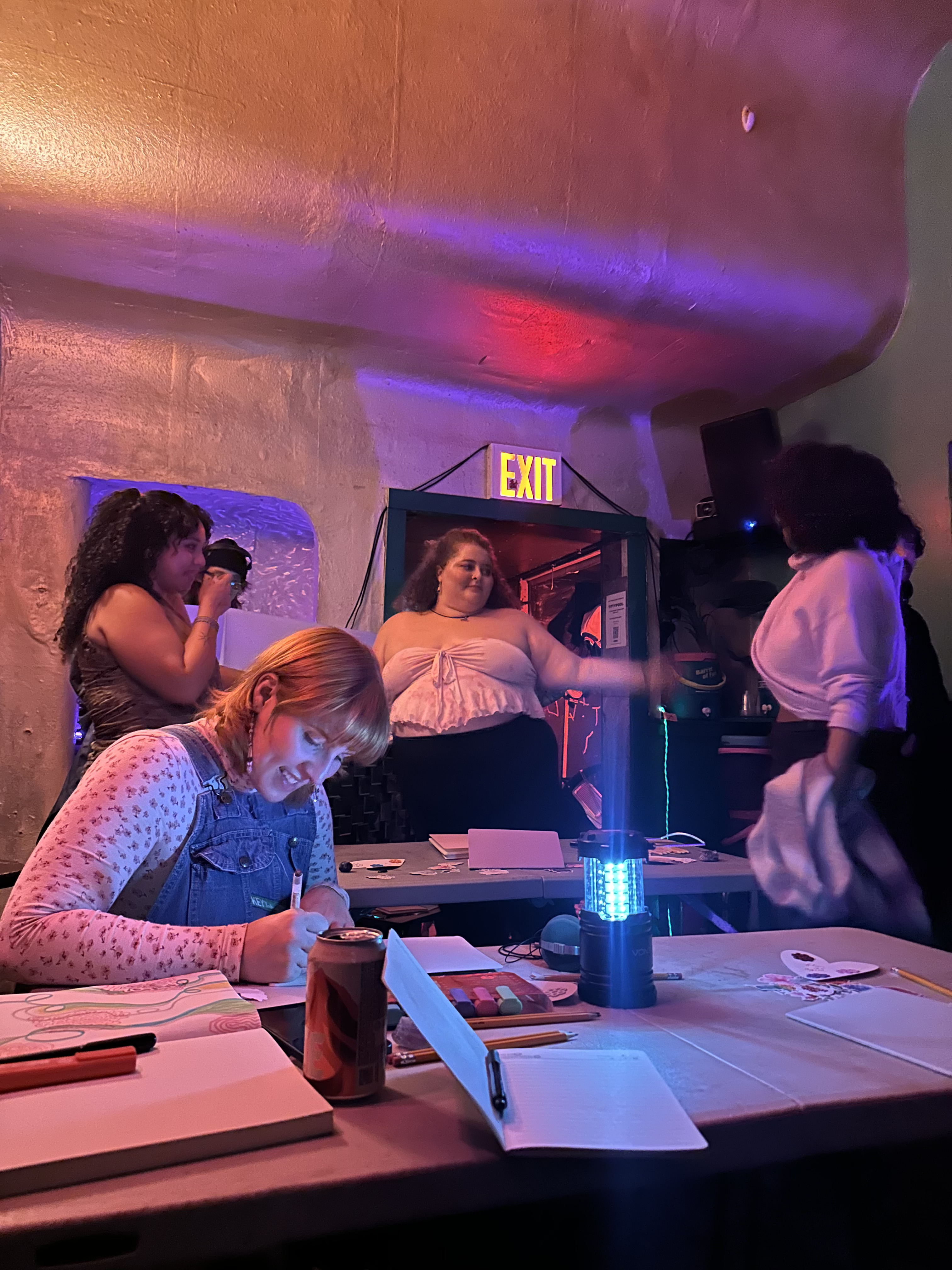 Amelie talks with friends at a 
                        writing workshop.